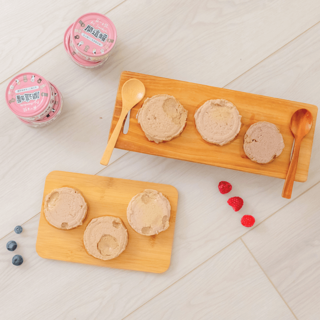 開這罐 保護肝臟【鱈魚鮪魚】白藜蘆醇機能主食罐 80g 在木板上擺放，旁邊有漿果和湯匙